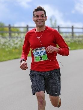 Vassos Alexander smiling while wearing red long sleeves, black shorts and earphone