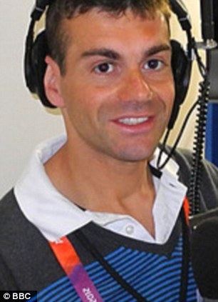 Vassos Alexander smiling while wearing a headphone and polo shirt