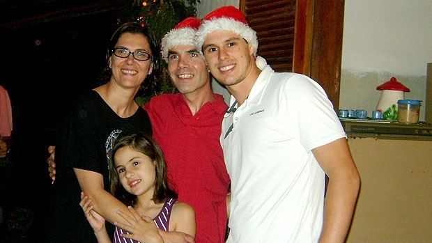 Vera Mossa smiling with her three children, Luisa, Edinho, and Bruninho while she is wearing a black blouse and eyeglasses