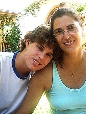 Vera Mossa smiling and wearing a sky blue tank top, eyeglasses, and necklace while Bruninho wearing a white and blue t-shirt