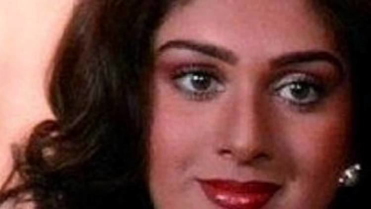 Meenakshi Seshadri as Sapna smiling with curled hair and red lipstick in a scene from Vijay, 1988.