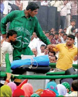Vikas Uppal along with a crowd of people wearing a green jacket and long pants.