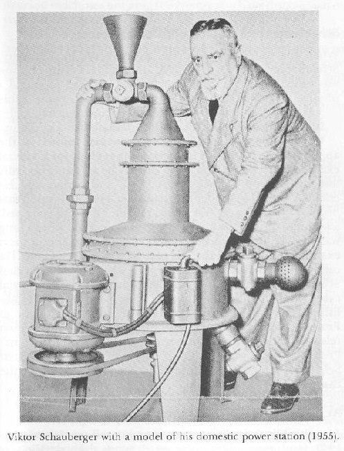 Viktor Schauberger holding the model of his domestic power station – the Trout Turbine while he is wearing a coat, long sleeves, necktie, pants, and shoes