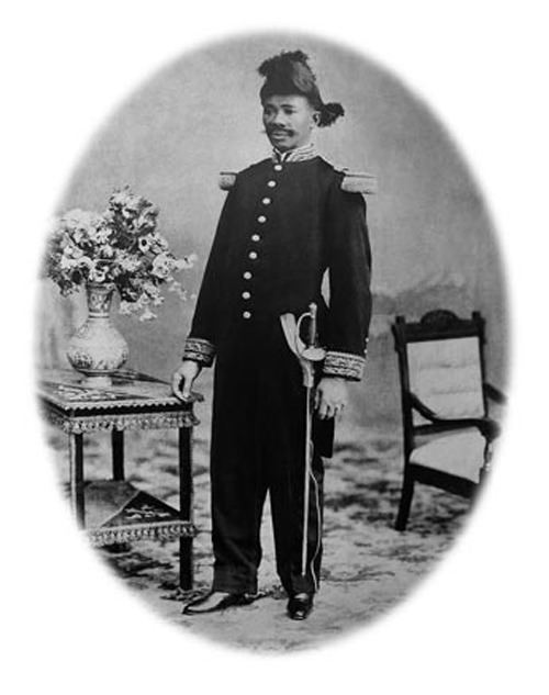 Vilbrun Guillaume Sam with mustache while wearing black long sleeves with gold details, black pants, and a hat