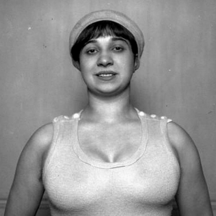 Violette Morris smiling while wearing a french beret and sleeveless top