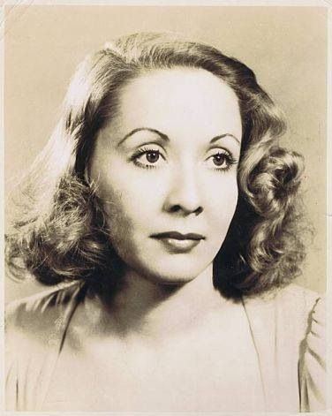 Vivian Vance is serious while looking to the right, has short curly hair, wearing a white top.