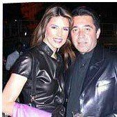 On the left Christina Estrada is smiling, standing with her right hand bent holding a pink scarf, has brown hair wearing a black shoulder bag and a black leather top, at the right, Walid Juffali is serious, standing, has black hair wearing a black turtleneck and a black leather jacket.