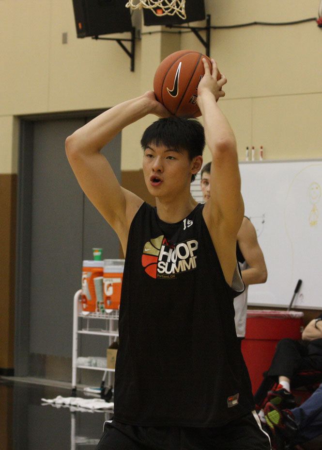 Wang Zhelin playing basketball while wearing a black printed sando