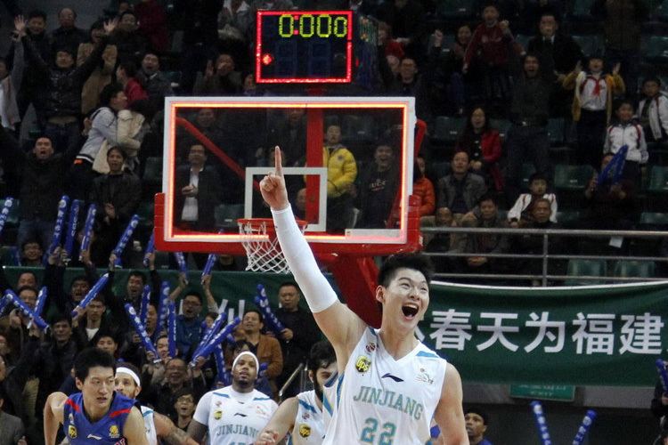 Wang Zhelin scream out of joy while pointing his finger and wearing a white and blue jersey with the number 22
