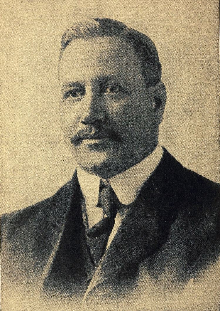Portrait of William G. Morgan with mustache while wearing a black coat, white long sleeves, vest, and necktie