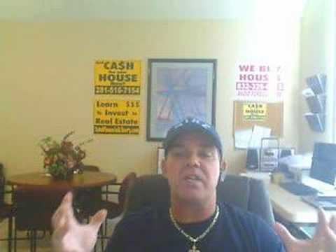 William J. McCorkle inside a room wearing a blue shirt, a hat, and a necklace