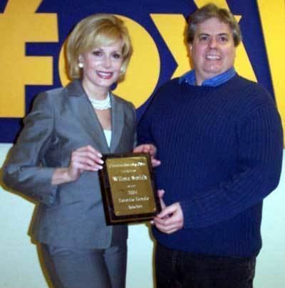 Wilma Smith receiving an award from Dan Hanson after being voted as  'Favorite Female News Anchor' by the fans