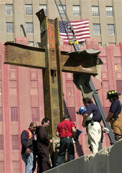 Father Brian Jordan, a Franciscan Priest, blesses The World Trade Center Cross together with the six men around it