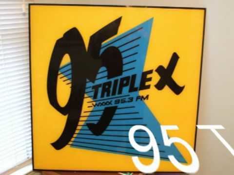 WXXX's logo, "95 Triple X- WXXX 95.5 fm" written on the board with black text color and a yellow and blue background