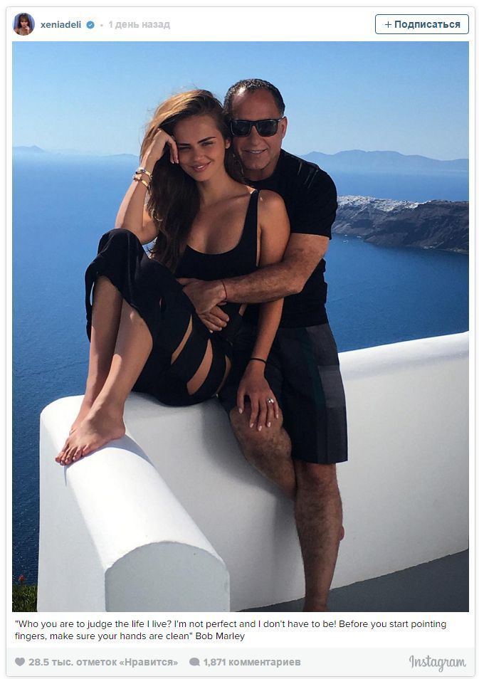 Xenia Deli's Instagram post, smiling while sitting on the fence with her husband, Ossama Fathi Rabah Al-Sharif