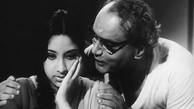Y. G. Parthasarathy's hand on her face while man's hands on her shoulder