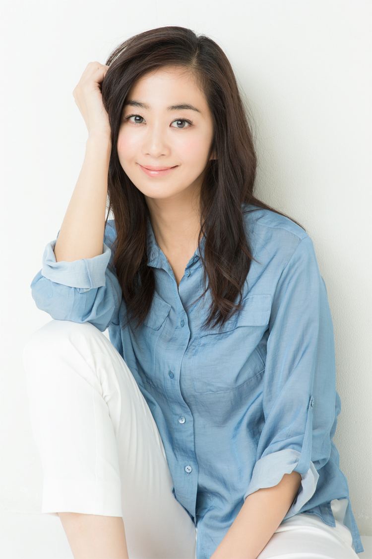 Yuka in her beautiful smile while wearing blue long sleeves and white pants