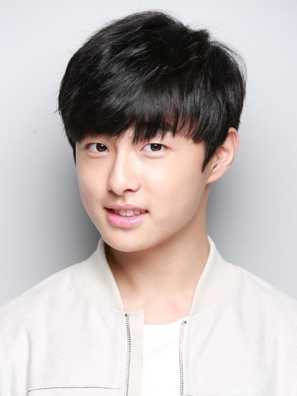 Yoon Chan-young smiling is a South Korean actor, with bangs and black hair, wearing a white shirt and an off-white zip-jacket.