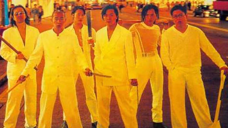 The casts of the 1996 film Young and Dangerous 2 starring- Ekin Cheng, Jordan Chan, Gigi Lai, Anthony Wong Chau-sang, Chingmy Yau, and Jerry Lamb standing while holding a stick and shovel on the street and all wearing white clothes.