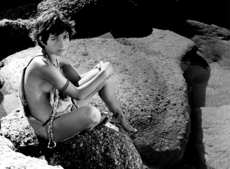 Cleopatra Rota sitting on a rock in the 1963 film "Young Aphrodites"