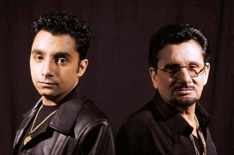 Yudhvir Manak wearing black leather jacket and his father Kuldeep Manak wearing eyeglasses and black long sleeves