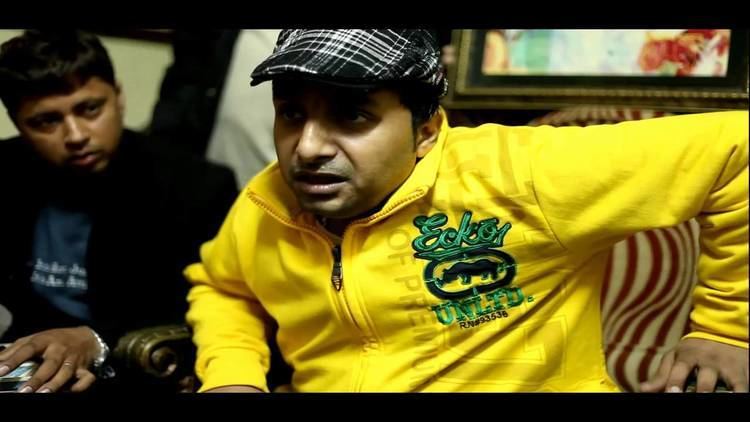 Yudhvir Manak wearing checkered hat and yellow jacket