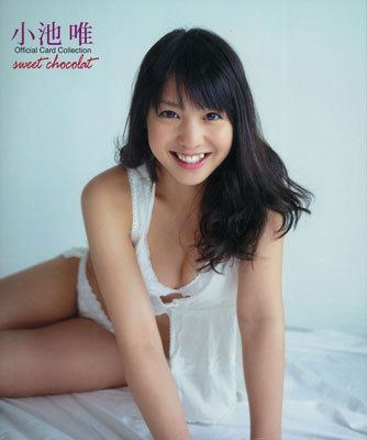 Yui Koike smiling and wearing white lingerie and a white swimsuit.