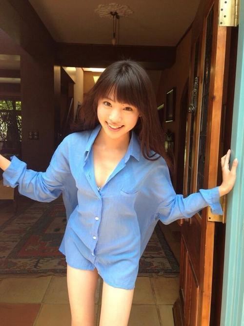 Yuumi Shida smiling and posing in a house while wearing a blue lace dress.