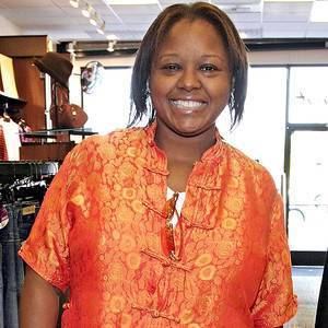 Yvette Wilson smiling while wearing an orange blouse