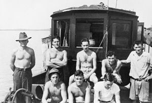 The crew of the MV Krait during Operation Jaywick, 1943 in a boat at the ocean, most of them are topless but all of them wear short pants