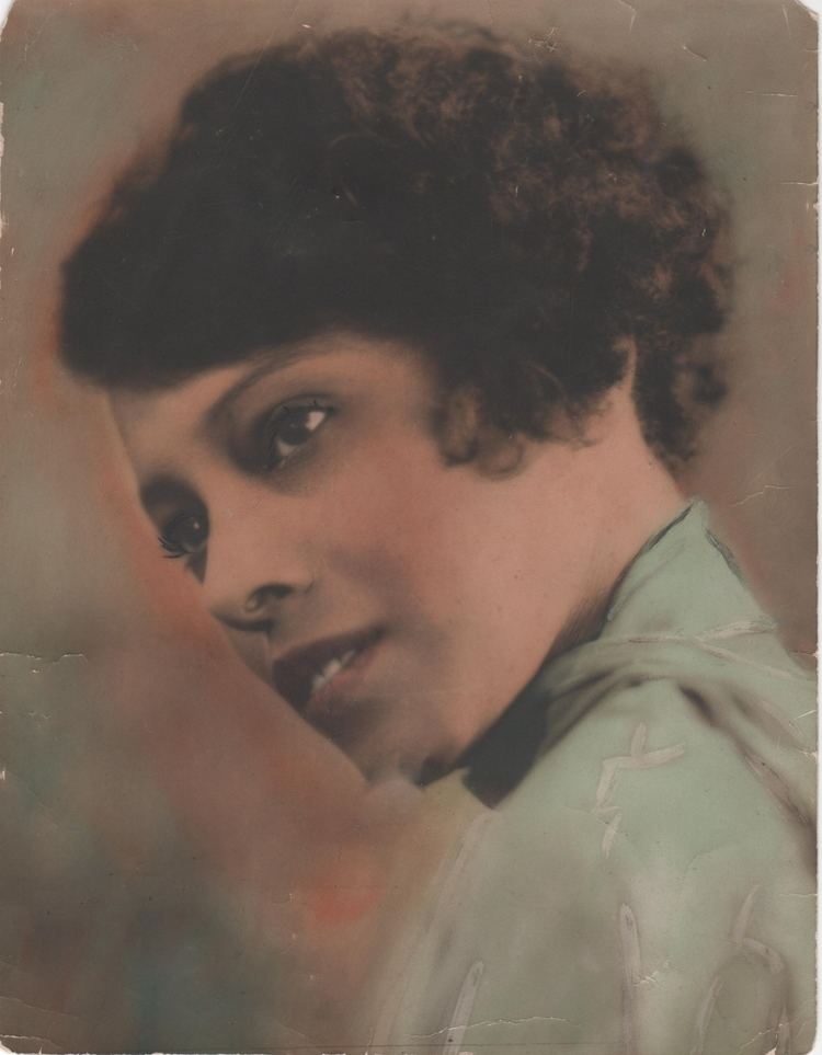 Portrait of Zara Cully while looking at something and wearing a green blouse