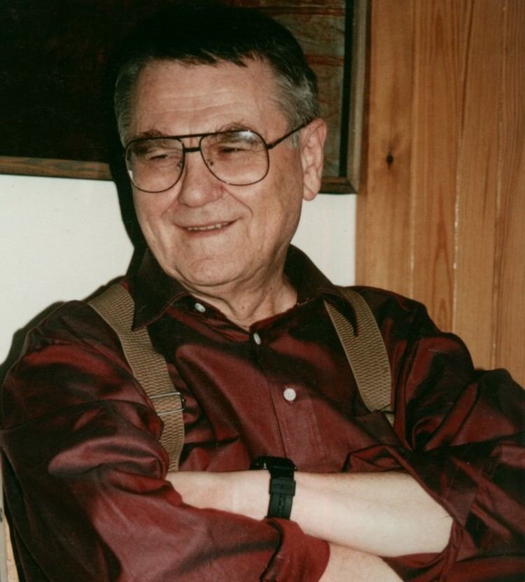 Zdzisław Beksiński wearing eyeglasses, red long sleeves, and a black watch.