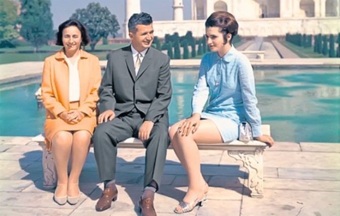 Zoia Ceausescu sitting down near the Taj Mahal with two companions and wearing a sky blue dress.