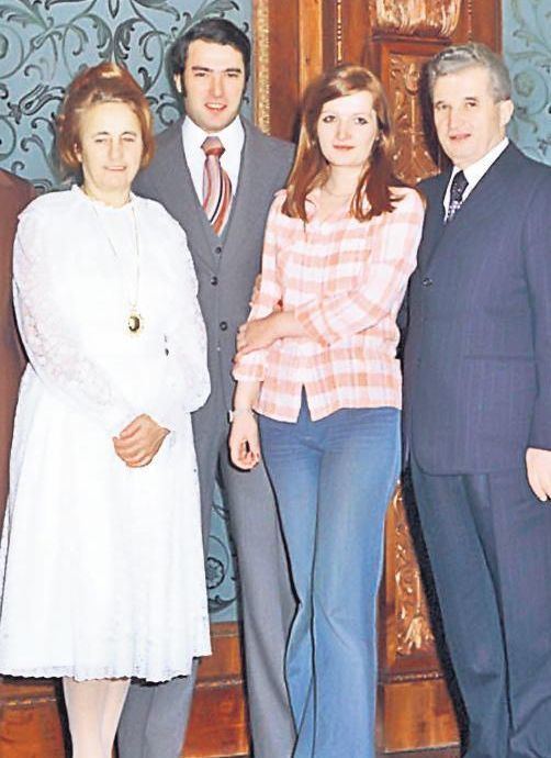 Zoia Ceaușescu posing with her family and wearing a striped dress and jean pants.