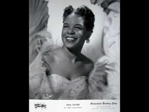 Zola Taylor smiling and wearing a gown.